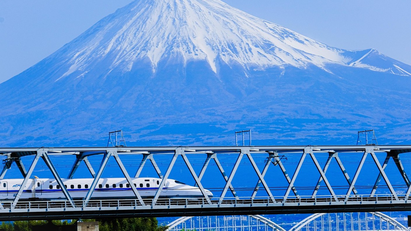 รถไฟชินคันเซ็นวิ่งผ่านสะพานโดยมีภูเขาไฟฟูจิเป็นฉากหลัง